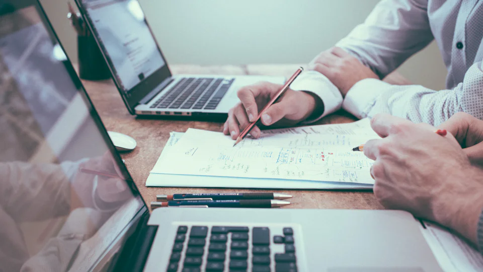 Two people going through documents together across a table