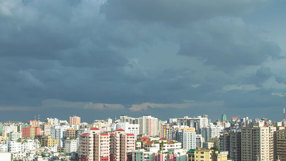 Mid-rise buildings across Dhaka under a heavy monsoon sky